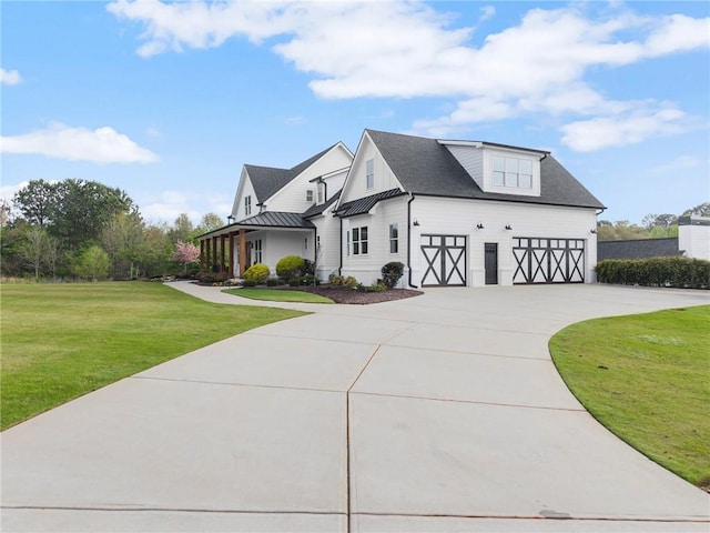 view of front of house featuring a front lawn, an attached garage, a standing seam roof, driveway, and metal roof