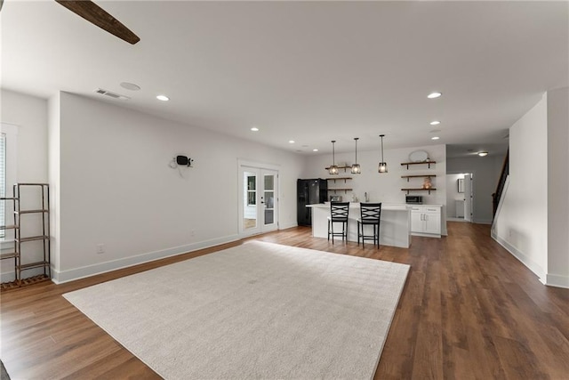 unfurnished living room with baseboards, visible vents, recessed lighting, and dark wood-style flooring