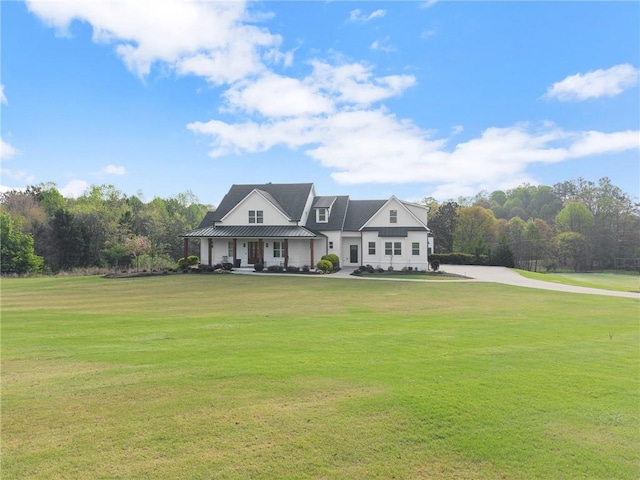 modern inspired farmhouse with a front lawn, a porch, and metal roof