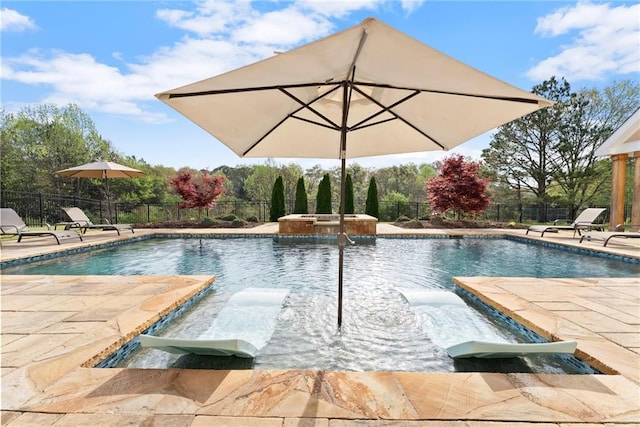 view of swimming pool featuring a patio area, a pool with connected hot tub, and a fenced backyard