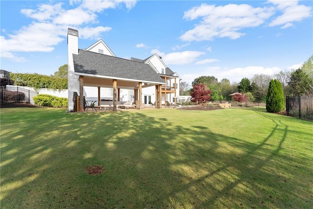 rear view of property with fence, a patio area, and a yard