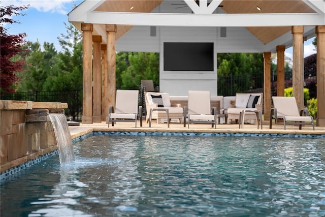pool featuring a gazebo, ceiling fan, and fence