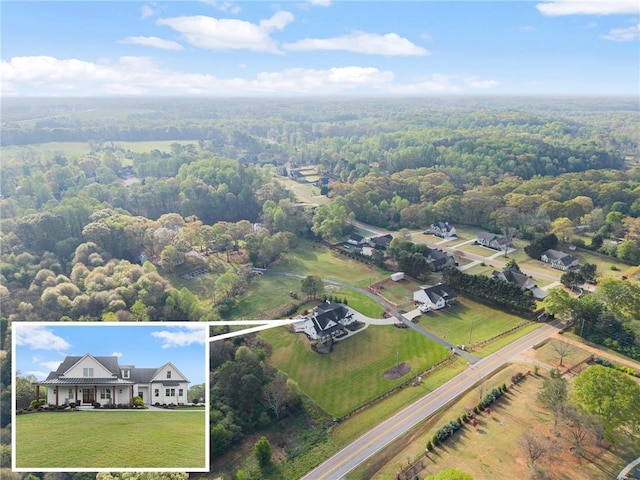 birds eye view of property featuring a view of trees
