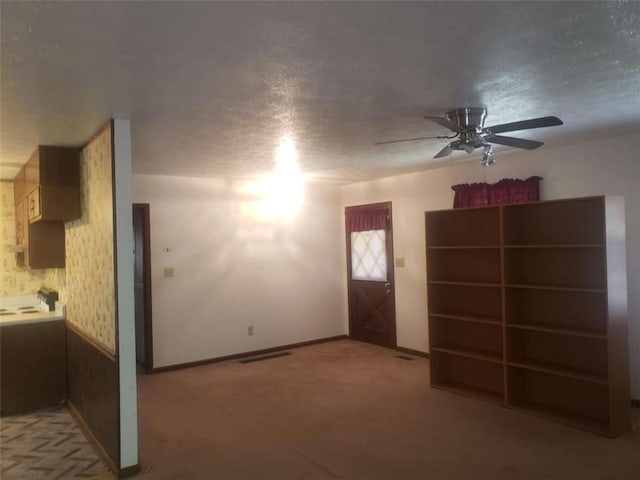 5927 Sherrie Ln, Powder Springs, GA 30127 - unfurnished living room featuring a ceiling fan, a textured ceiling, light colored carpet, visible vents, and baseboards