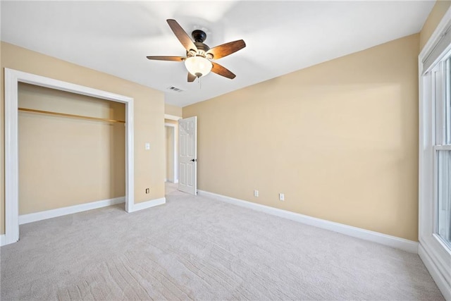 unfurnished bedroom featuring ceiling fan, light colored carpet, and a closet