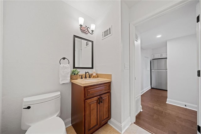 bathroom featuring tile patterned floors, vanity, and toilet