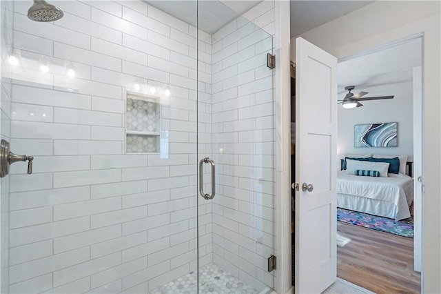 bathroom featuring ceiling fan, a shower with shower door, and hardwood / wood-style flooring