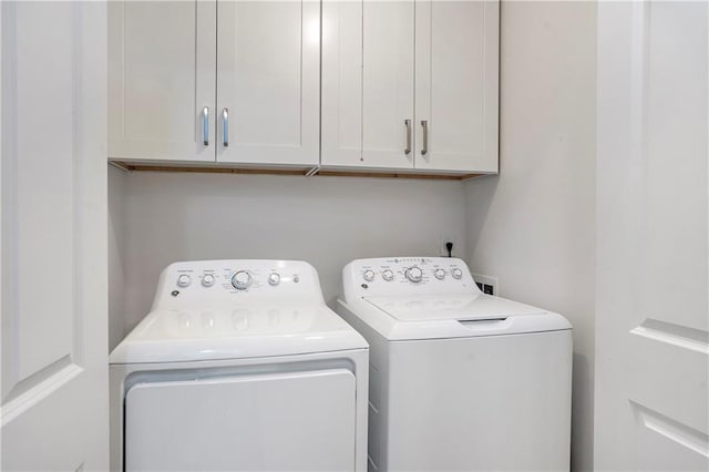 laundry room featuring cabinets and washer and clothes dryer