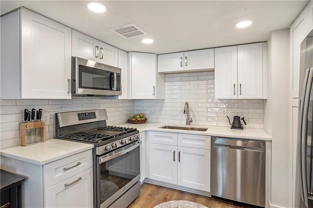 kitchen with sink, stainless steel appliances, and white cabinetry