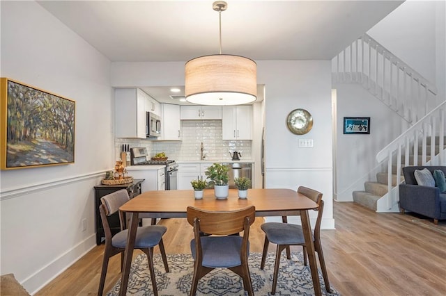 dining room featuring sink and light hardwood / wood-style flooring