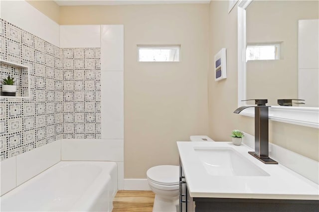 full bathroom featuring vanity, tiled shower / bath, hardwood / wood-style floors, and toilet