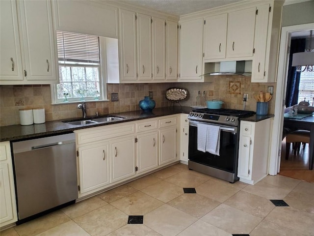 kitchen with decorative backsplash, wall chimney exhaust hood, stainless steel appliances, a sink, and light tile patterned flooring