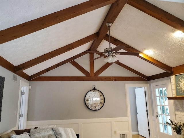 details featuring ceiling fan, a textured ceiling, visible vents, wainscoting, and beam ceiling