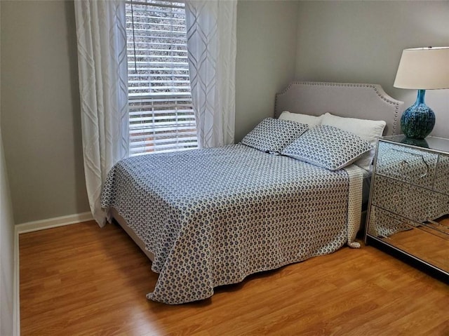 bedroom featuring baseboards and wood finished floors