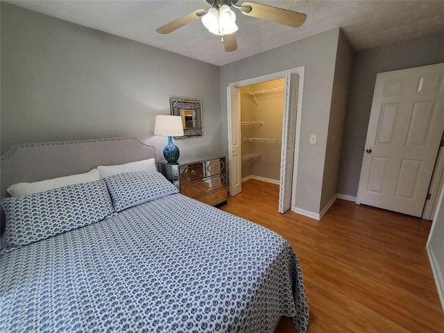 bedroom with baseboards, a ceiling fan, and light wood-style floors