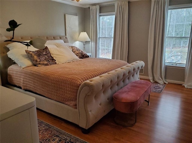 bedroom featuring crown molding, wood finished floors, and baseboards