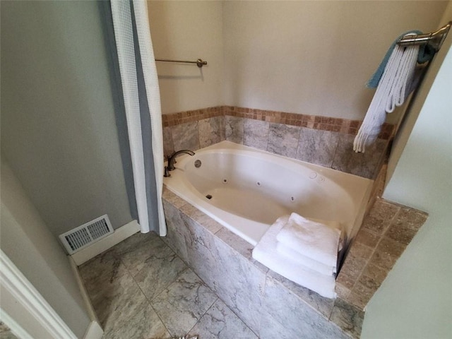 full bathroom with visible vents, a jetted tub, and baseboards