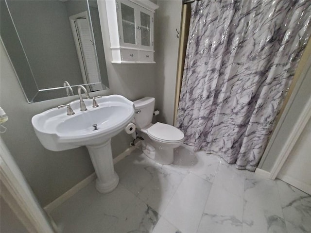 bathroom featuring a shower with curtain, marble finish floor, baseboards, and toilet