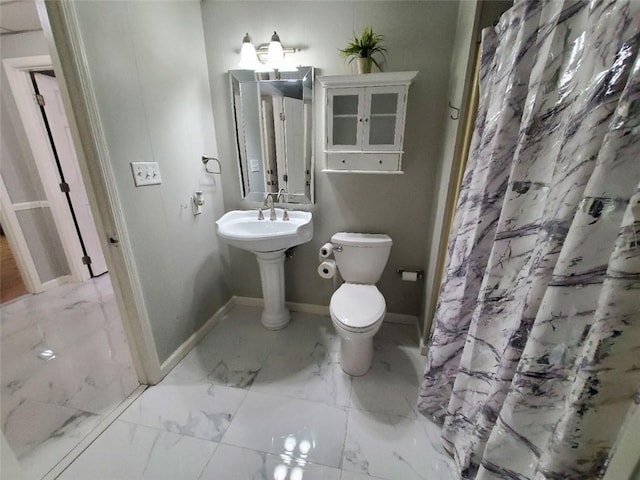 full bathroom with marble finish floor, baseboards, and toilet