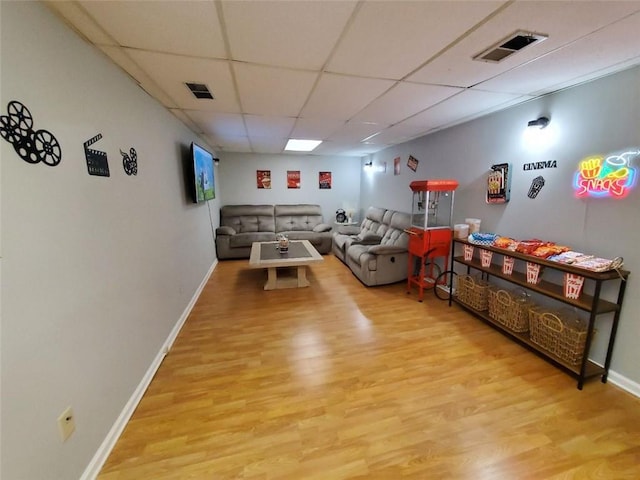 rec room with a paneled ceiling, baseboards, visible vents, and wood finished floors