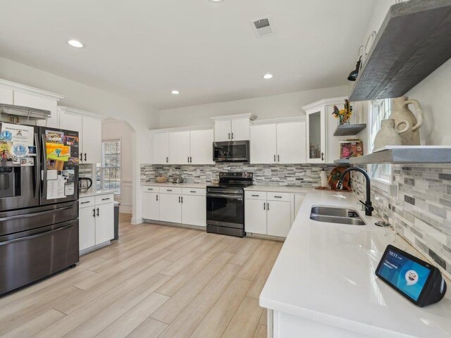 kitchen with a sink, light countertops, tasteful backsplash, and stainless steel appliances