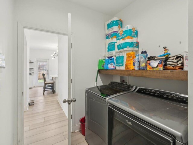 washroom featuring light wood finished floors, a notable chandelier, laundry area, and separate washer and dryer