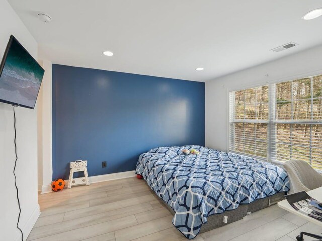 bedroom with recessed lighting, wood finished floors, visible vents, and baseboards
