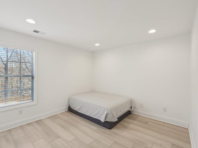 bedroom with recessed lighting, visible vents, baseboards, and light wood finished floors