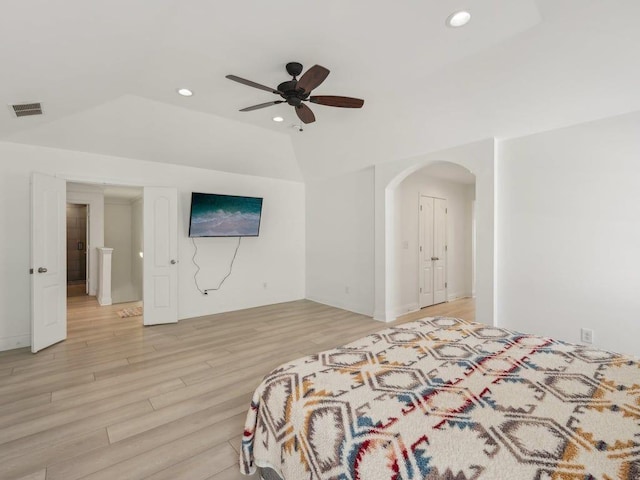 bedroom featuring visible vents, lofted ceiling, recessed lighting, arched walkways, and light wood-style floors