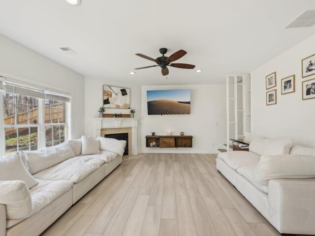 living room featuring recessed lighting, a ceiling fan, visible vents, and light wood-type flooring
