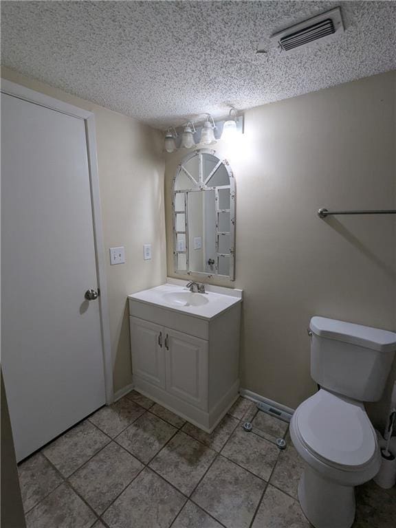 bathroom with a textured ceiling, toilet, and vanity