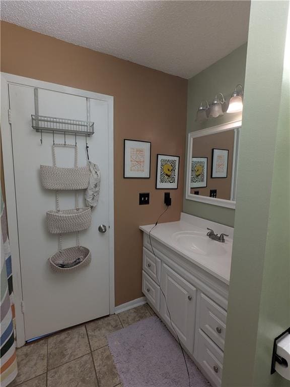 bathroom featuring vanity, tile patterned floors, and a textured ceiling