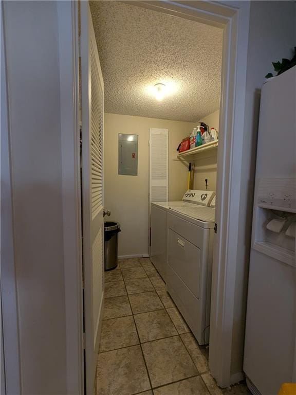 laundry room featuring washer and clothes dryer, light tile patterned floors, a textured ceiling, and electric panel