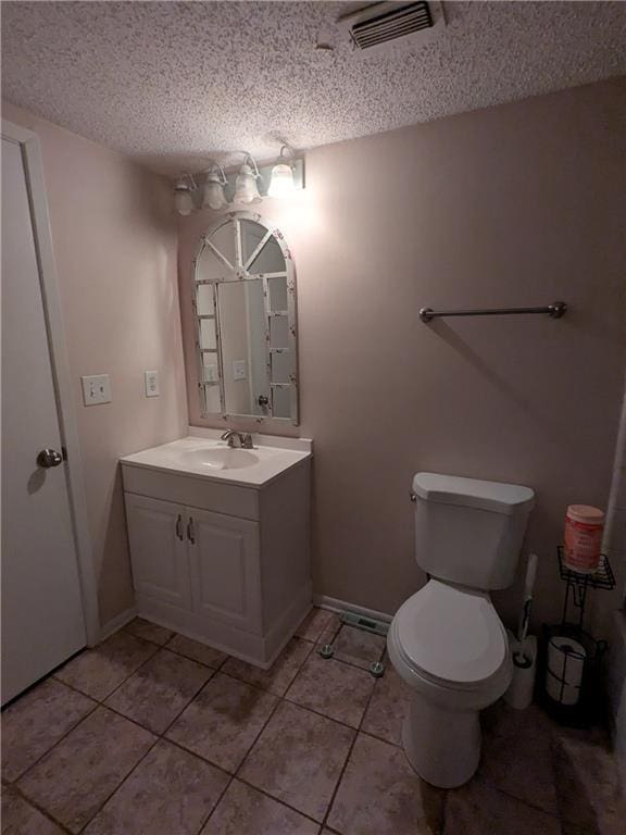 bathroom with toilet, vanity, and a textured ceiling