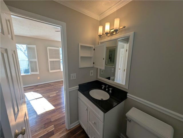 bathroom featuring ornamental molding, wood-type flooring, vanity, and toilet