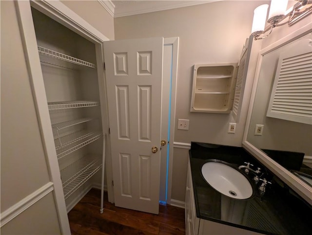 bathroom with vanity, crown molding, and hardwood / wood-style flooring