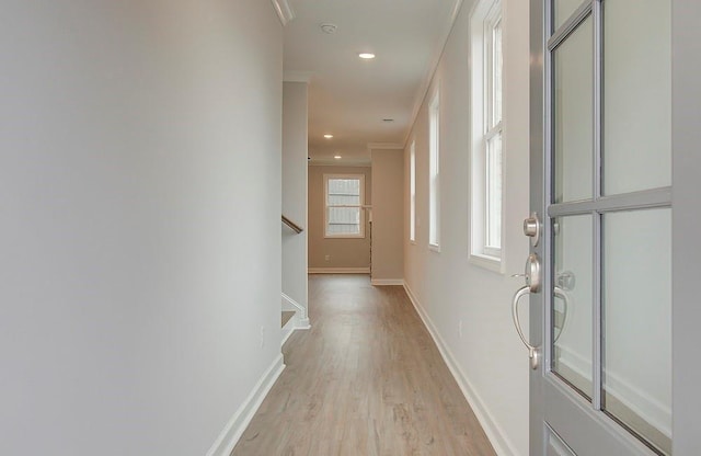 hallway featuring crown molding and light hardwood / wood-style flooring