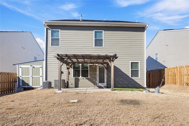 rear view of house featuring central AC, a pergola, a patio area, and a shed