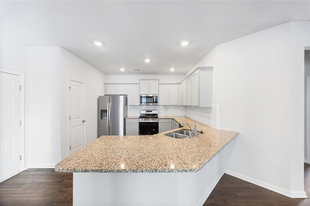 kitchen featuring sink, white cabinetry, appliances with stainless steel finishes, and kitchen peninsula