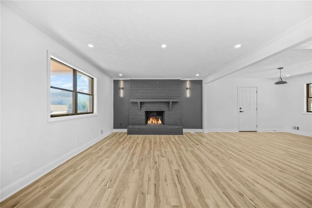 unfurnished living room featuring light wood-style flooring, recessed lighting, a brick fireplace, and baseboards