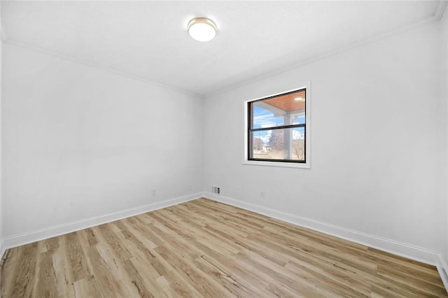unfurnished room featuring crown molding, light wood-style floors, and baseboards