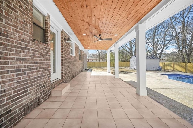 view of patio / terrace with a storage shed, an outdoor structure, a ceiling fan, and a fenced backyard