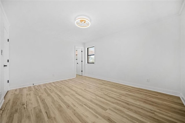 spare room featuring light wood-type flooring and baseboards