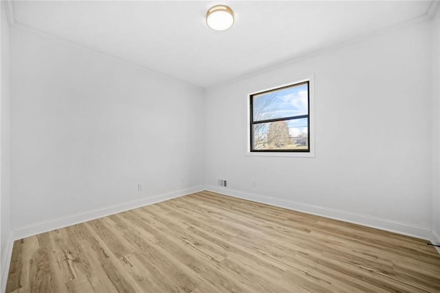 unfurnished room featuring light wood-style floors, baseboards, and crown molding