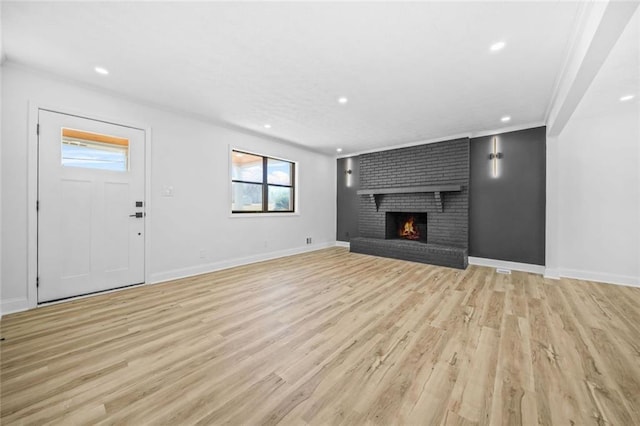 unfurnished living room featuring light wood-style flooring, recessed lighting, baseboards, and a brick fireplace