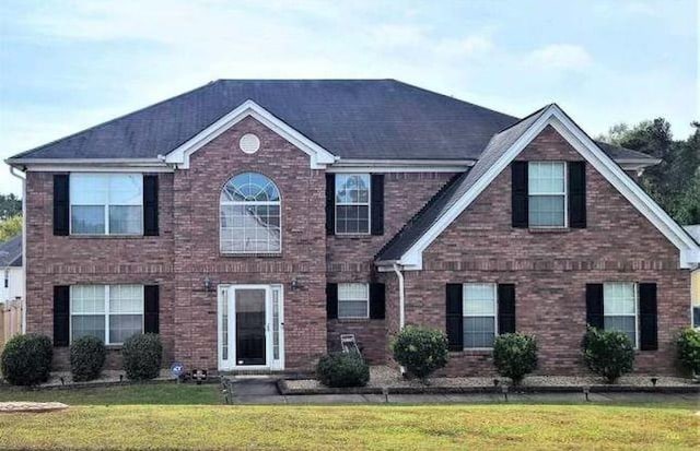 colonial-style house with a front lawn