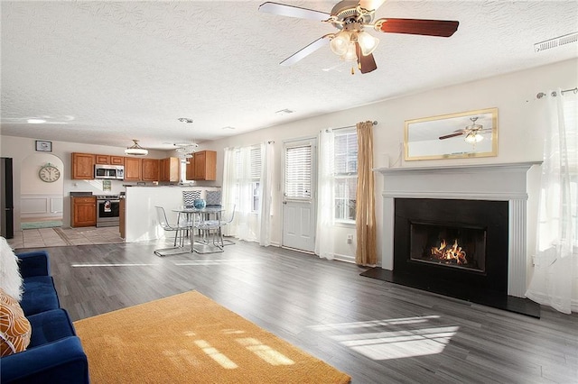 unfurnished living room featuring wood-type flooring, a textured ceiling, and ceiling fan