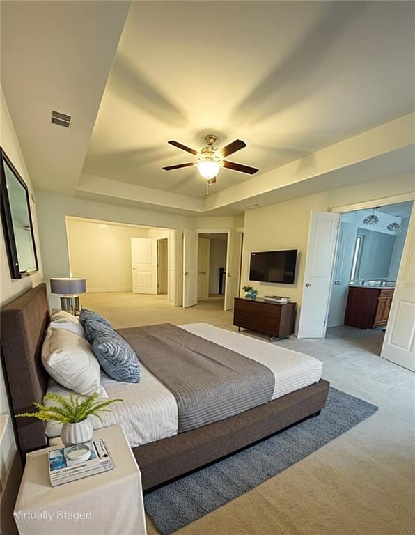 1147 Halletts Peak Pl, Lawrenceville, GA 30044 - bedroom featuring a tray ceiling, light carpet, ceiling fan, and ensuite bathroom