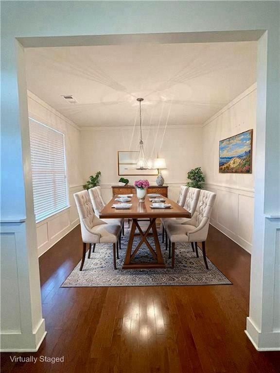 1147 Halletts Peak Pl, Lawrenceville, GA 30044 - dining space featuring wood finished floors, a decorative wall, ornamental molding, and wainscoting