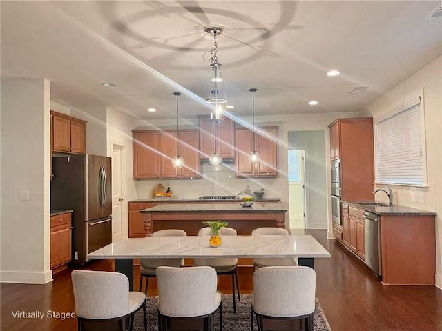 1147 Halletts Peak Pl, Lawrenceville, GA 30044 - kitchen featuring appliances with stainless steel finishes, a kitchen island, a sink, recessed lighting, and a kitchen bar